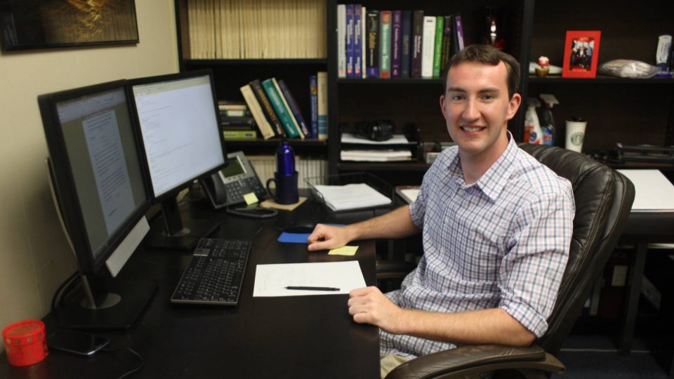 Charlie Costello seated at his desk