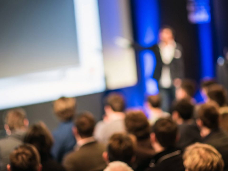 Speaker on stage in front of an audience