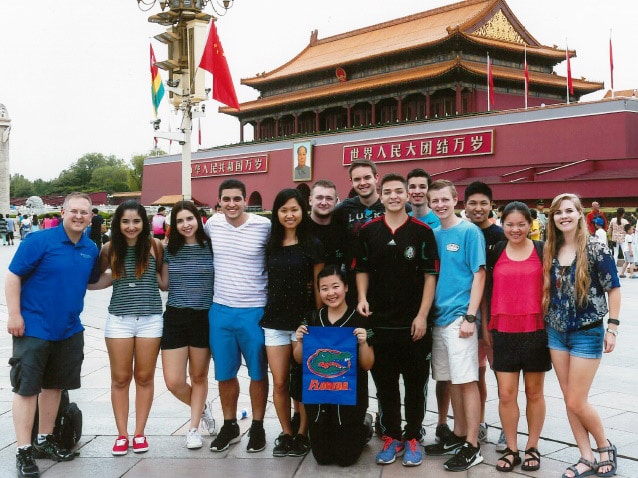 Jason Ward with students holding Florida Gator flag in the Forbidden City, in Beijing