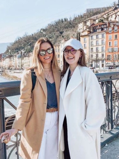 2 students outside in front of landscape in Grenoble, France during winter.