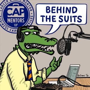 Illustration of a business gator saying "Behind the Suits" into a microphone and wearing headphones with a laptop sitting on the table in front of him.