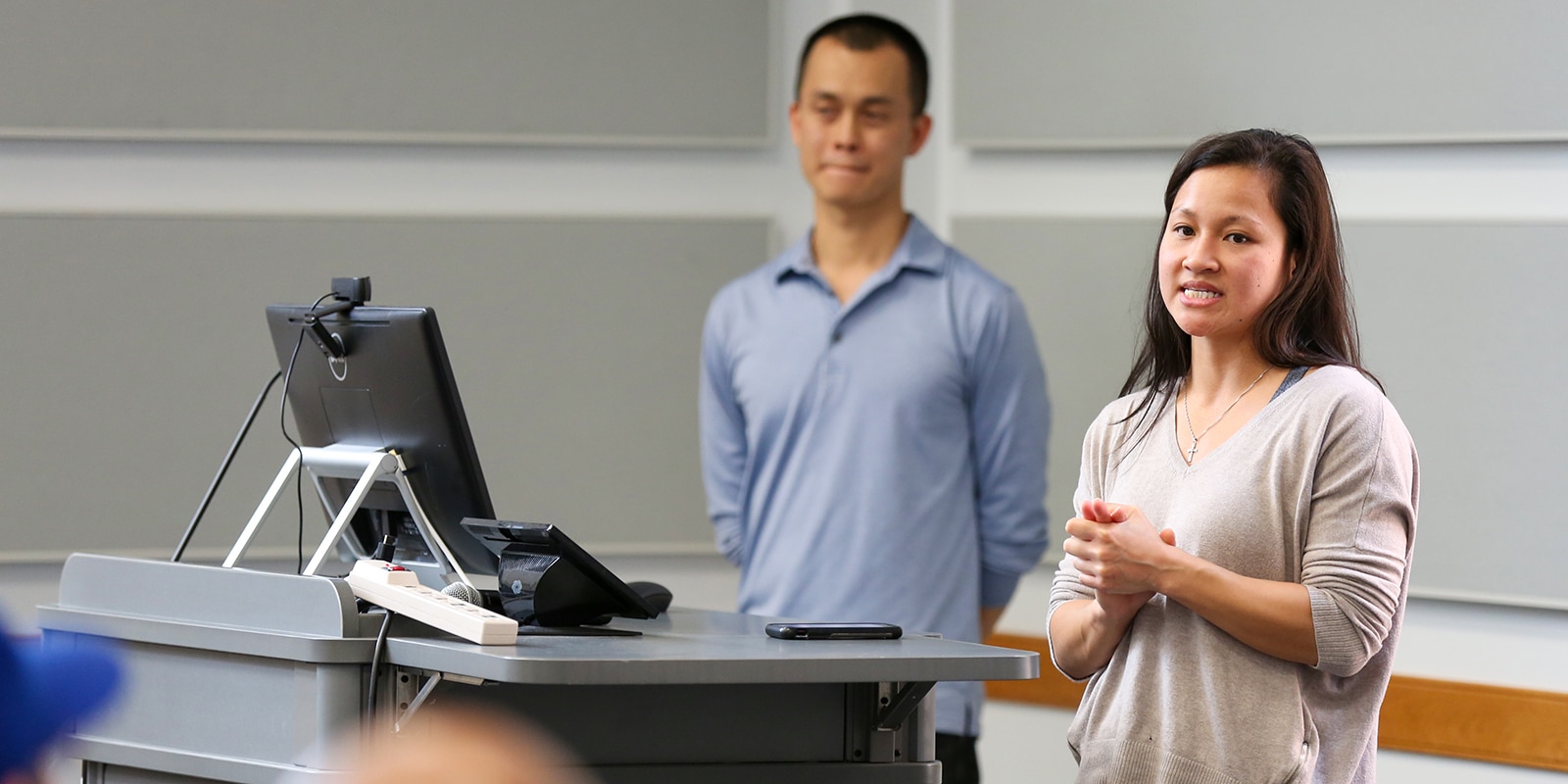 Two UF Warrington MS in Entrepreneurship students participating in the Lean Entrepreneurship Accelerator Program stand behind a podium to present their ideas