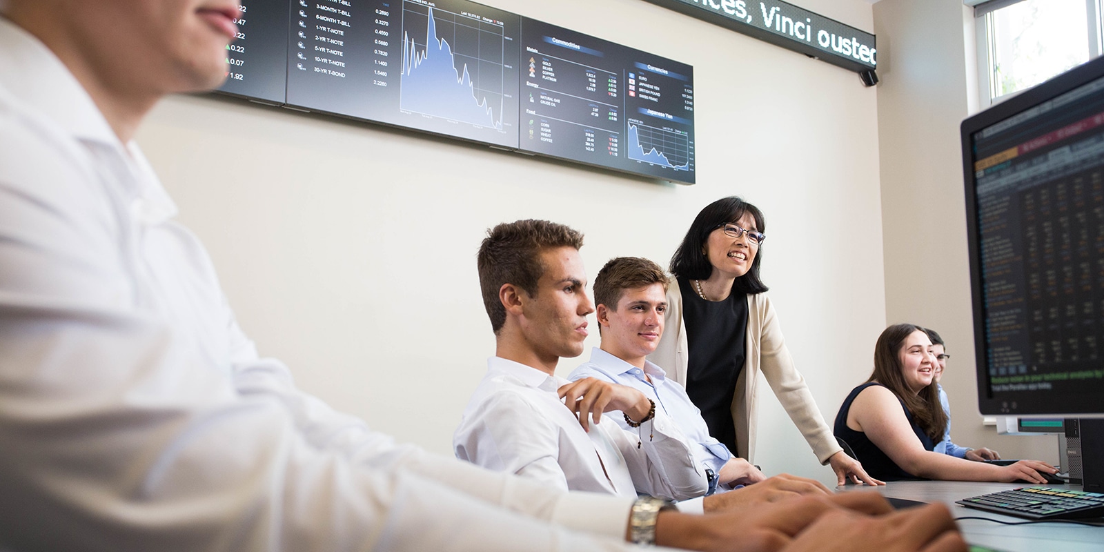 In front of computers, students from UF Warrington's MS in Finance program receive instruction in the Capital Markets Lab