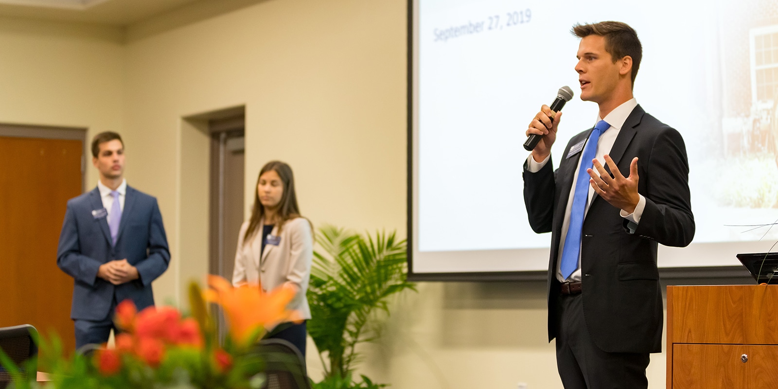 A student from UF Warrington's MS in Finance program points to his asset management project during a presentation to fellow students