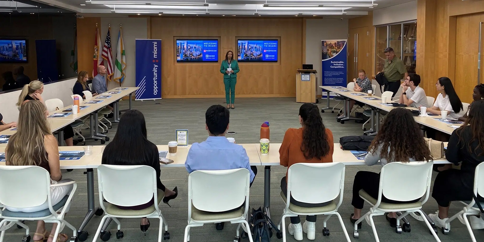 Sitting in a square formation, Master of International Business students from the University of Florida Warrington College of Business observe a presentation