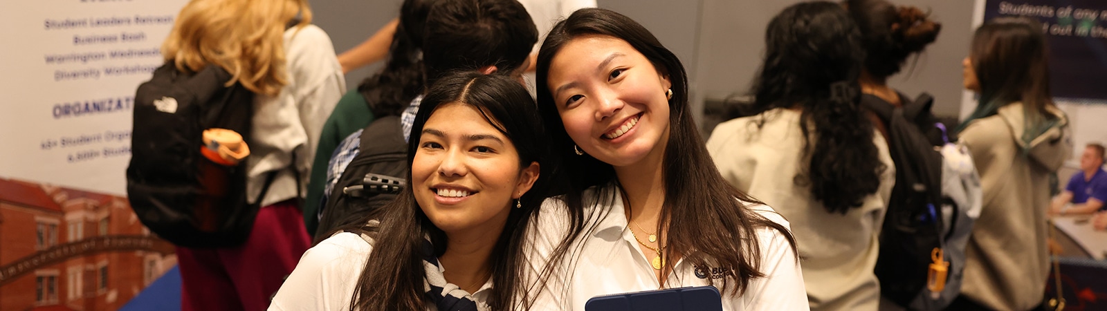 Two Warrington College of Business students pose and smile during an event for browsing the University of Florida's minors
