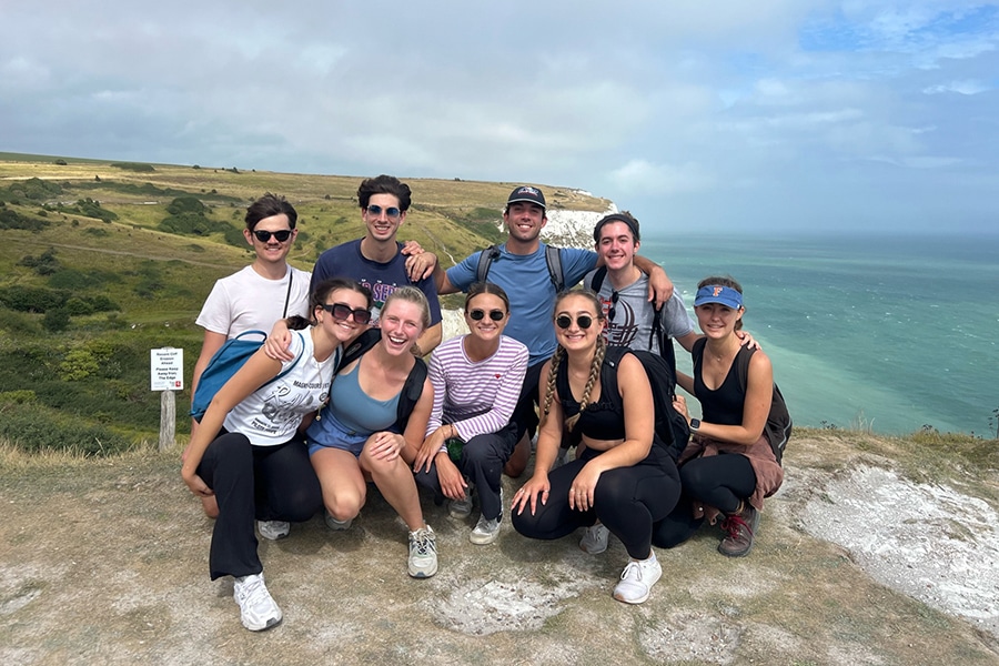 Students smiling and posing at a scenic outdoor location during a University of Florida Warrington College of Business study abroad trip.