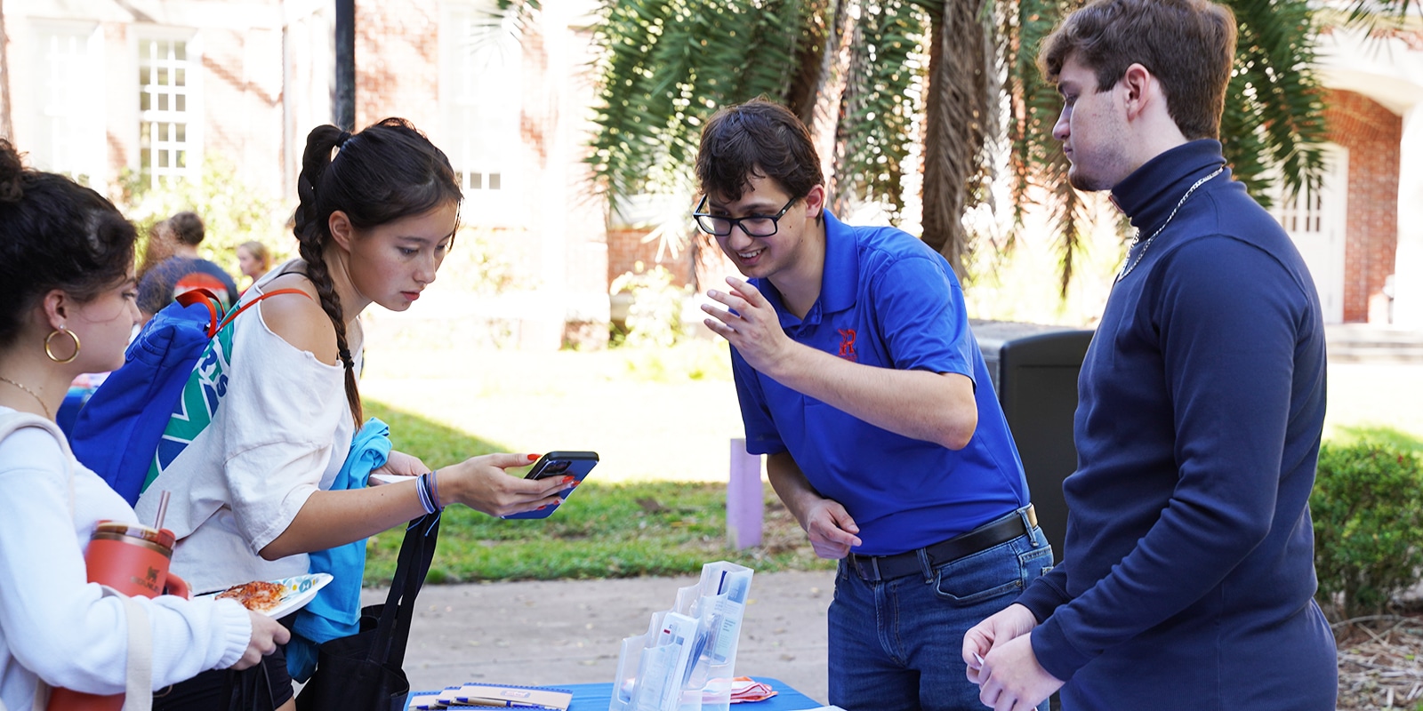 Gator Ready Student ambassadors helping a student use the app at a tabling event.