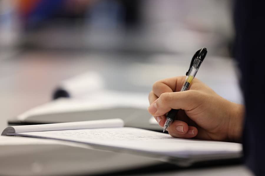 Hand writing on a pad of paper.