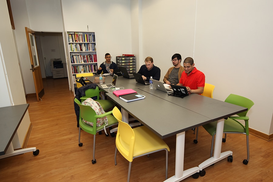Students working around a table together. 