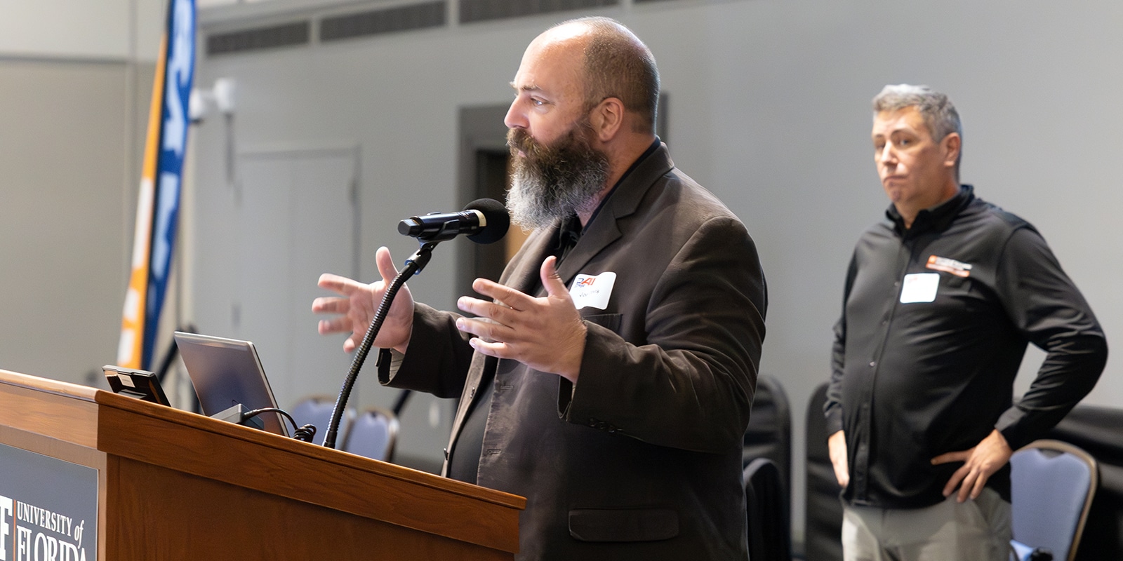 A professor affiliated with the University of Florida Warrington College of Business' Business Analytics and Artificial Intelligence Center speaks to a crowd of faculty and students, including those from the UF Warrington PhD in Information Systems and Operations Management program
