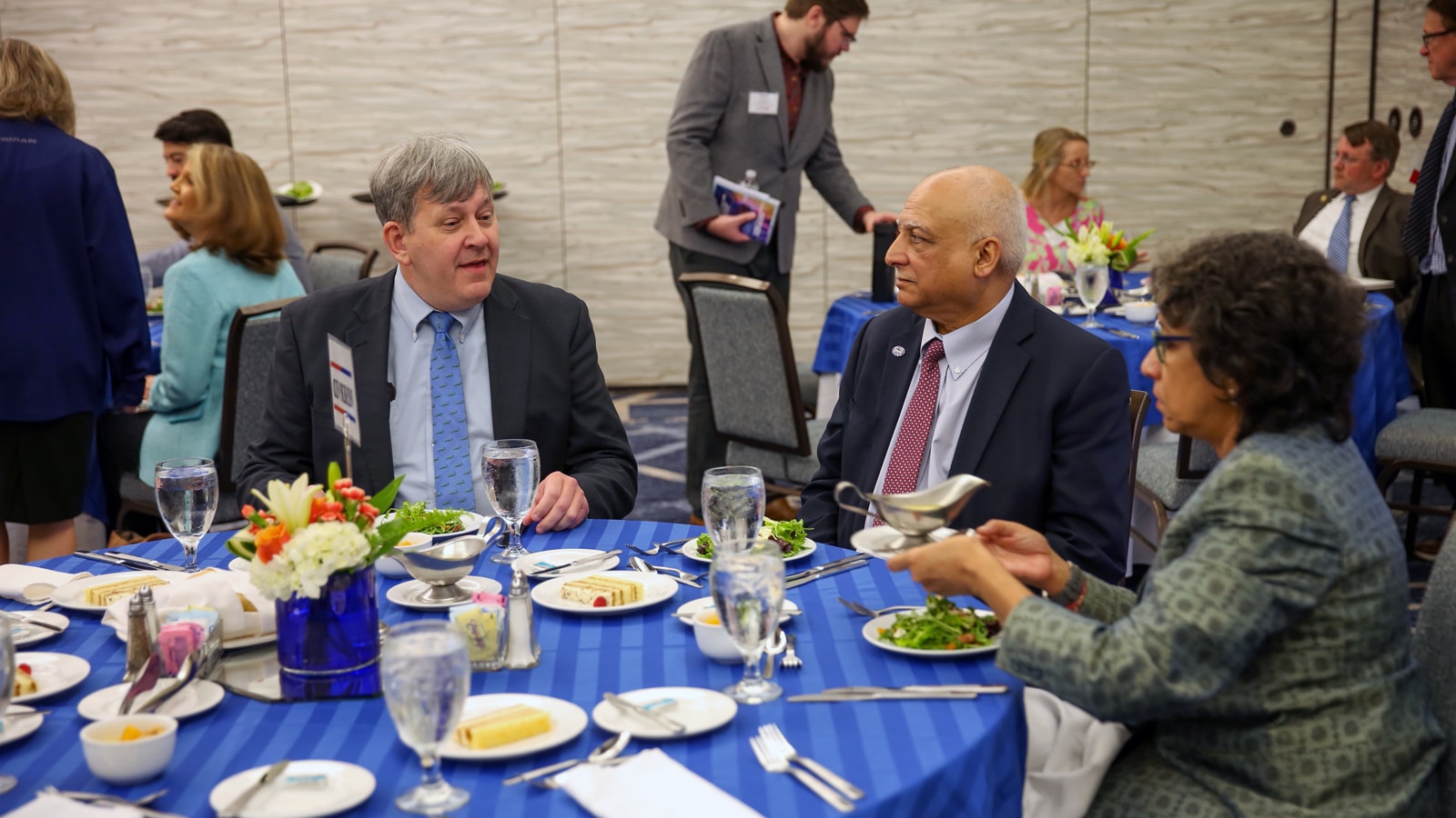 Attendees share a meal and conversation at a round banquet table during the PURC Annual Conference.