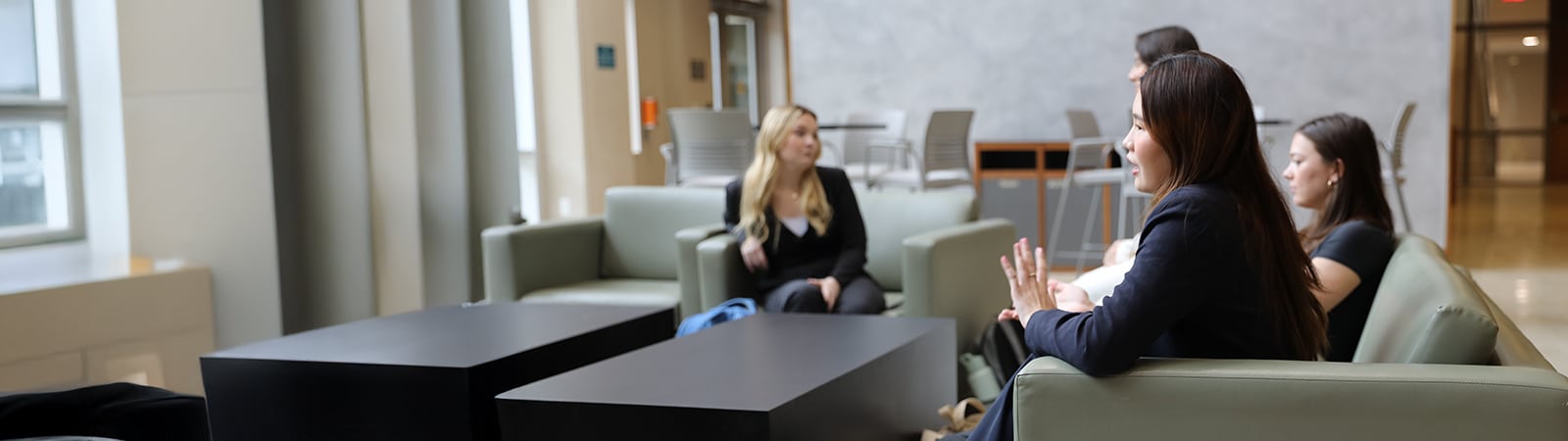 A female retail society student speaking to other students. 