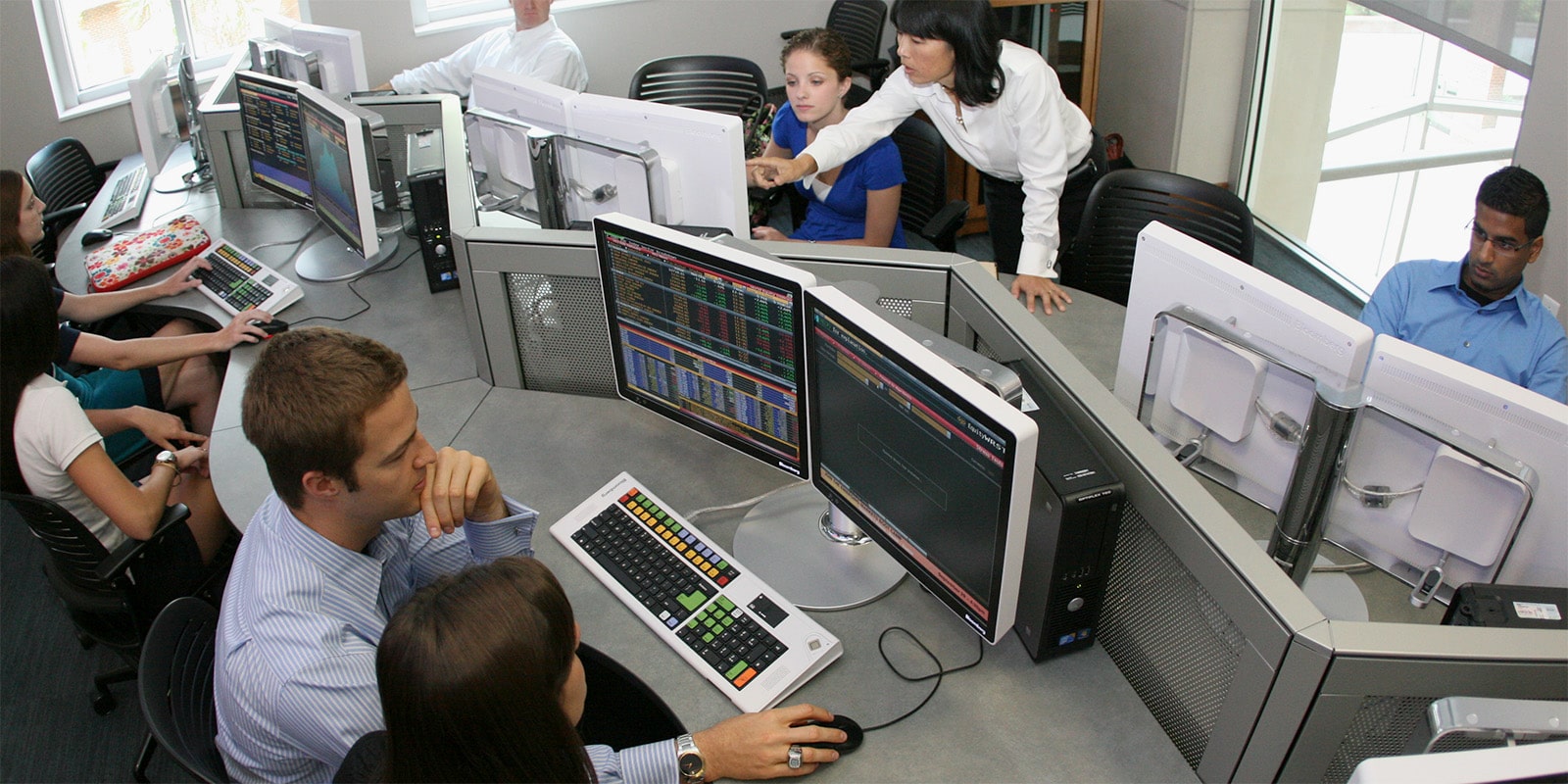Students and a professor working in a computer lab.