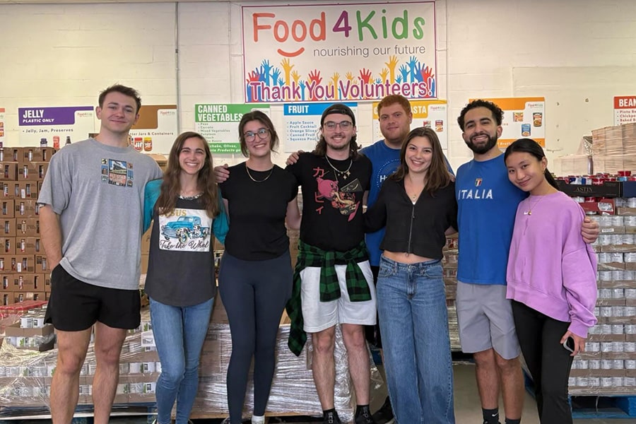 Hough ambassadors posing for a group photo in front of the Food4Kids sign.