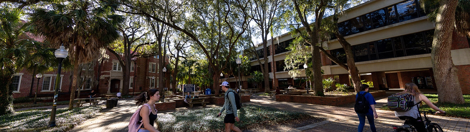 Students walking through the courtyard by Stuzin Hall at the Warrington College of Business.