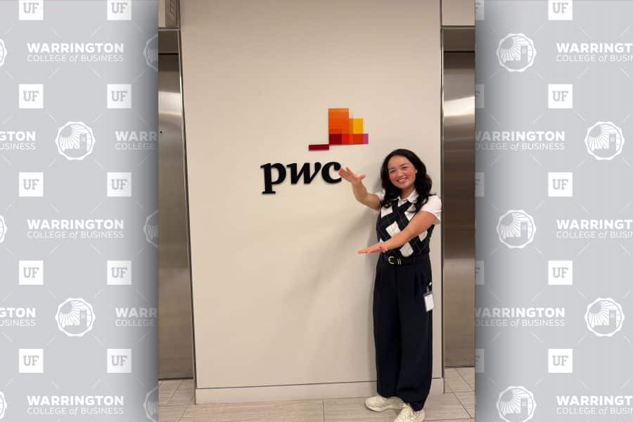 Minuet Greenberg doing the gator chomp in front of PwC sign