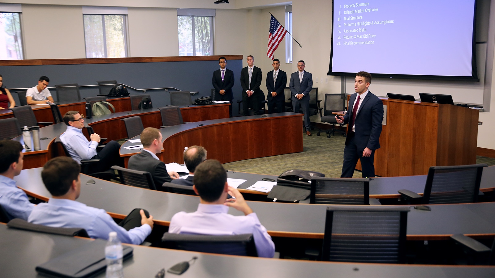 A group of students presenting to real estate professionals. 