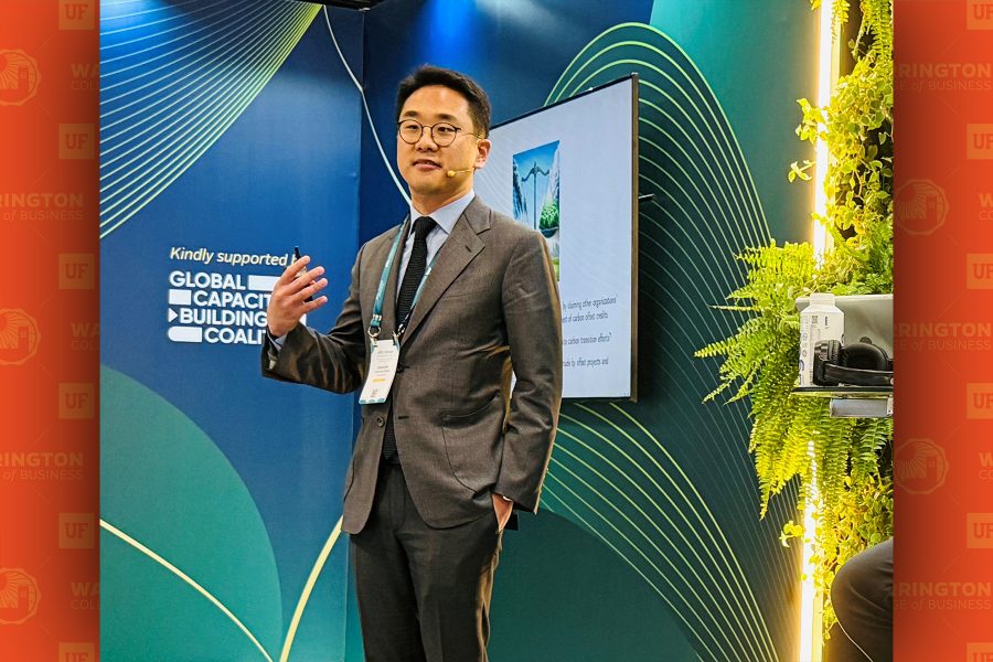 Sehoon Kim standing on a stage presenting his paper on stage at PRI in Person Conference