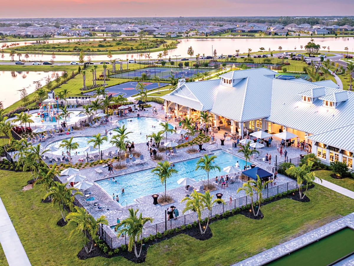 An aerial view rendering of the Lakewood Ranch development showing a clubhouse with pools, basketball and tennis courts, with lakes and houses surrounding it.